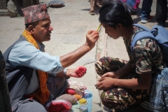Hindu Brahmane malt Tika (Segenszeichen) auf die Stirn