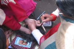 Erster Haarschnitt - Chudakarana - Birajs Zehen werden mit Sindur-Paste bestrichen
