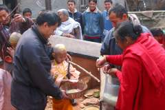 Erster Haarschnitt - Chudakarana -  Biraj bekommt von Angehörigen Reis gespendet