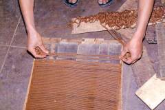 Herstellung tibetischer Räucherstäbchen - Schnüre werden gerade auf Holzbretter gelegt